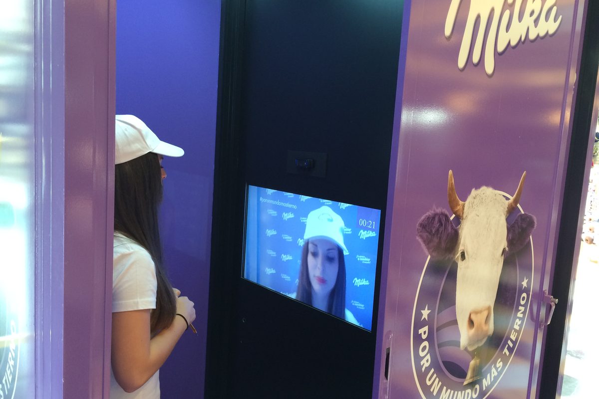 Escaparate táctil interactivo con una persona usando el cristal desde la calle Escaparate táctil interactivo con una persona usando el cristal desde la calle