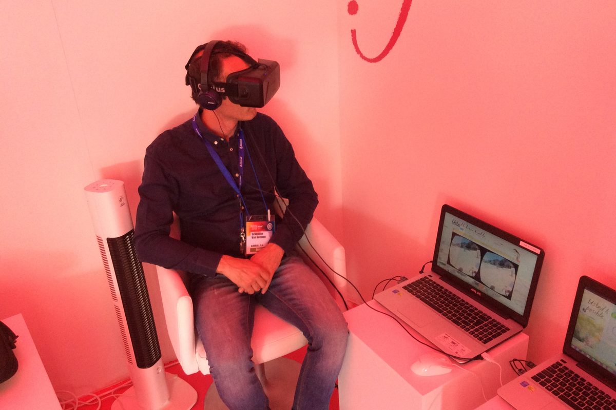 Visitante usando gafas de realidad virtual en el stand de una feria Visitante usando gafas de realidad virtual en el stand de una feria